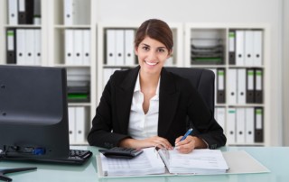 Female Accountant Writing On Desk